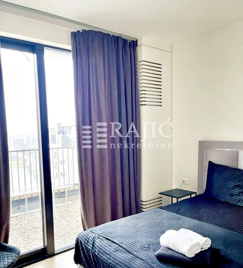 Bedroom with a double bed, dark curtains, and balcony access.