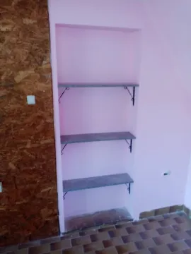 Built-in wall shelves in a room with pink walls. - image 12
