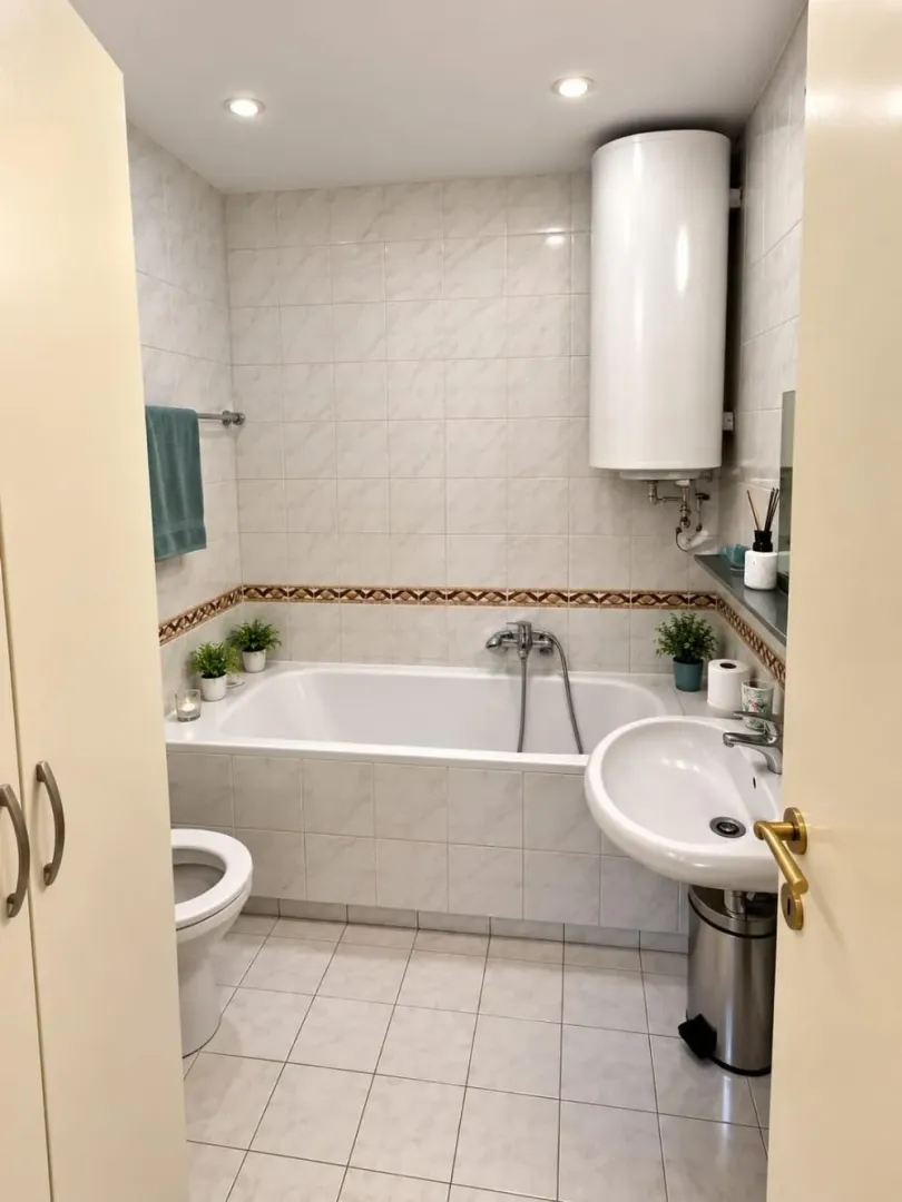 Pogled na kupatilo sa kadom, umivaonikom i ugrađenim bojlerom.