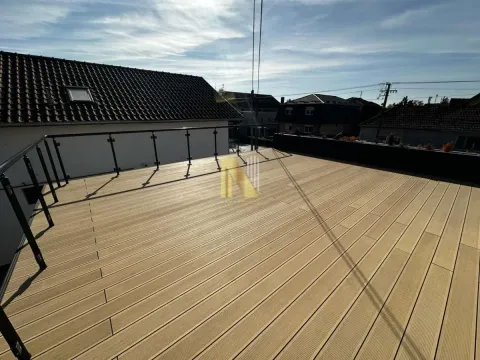 Spacious rooftop terrace with wooden decking and glass railing. - image 10