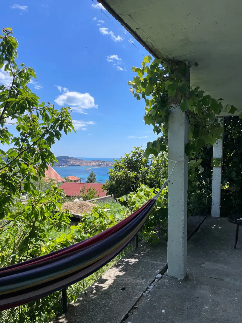 Natkrivena terasa sa ležaljkom i pogledom na more.