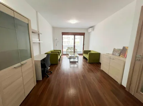 Living room with a sofa set, a desk, and wooden flooring. - image 5
