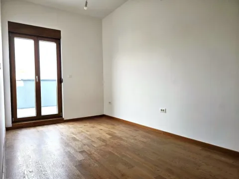 Empty room with hardwood floors and balcony doors. - image 17
