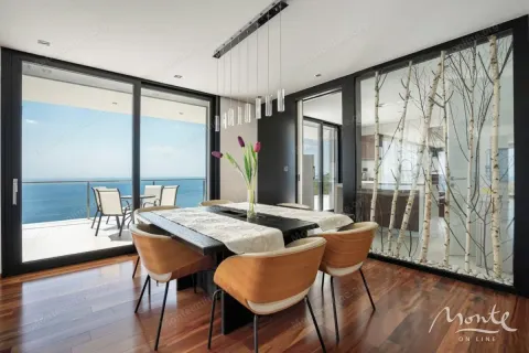 Modern dining room with a large table, glass wall, and sea view. - image 6