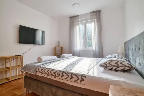 Svijetla spavaća soba sa bračnim krevetom, TV-om i prozorom. - image 6