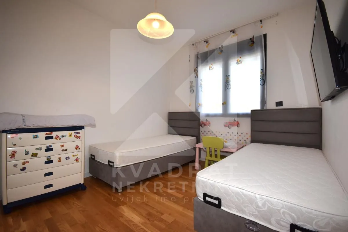Children's bedroom with two single beds and a chest of drawers.