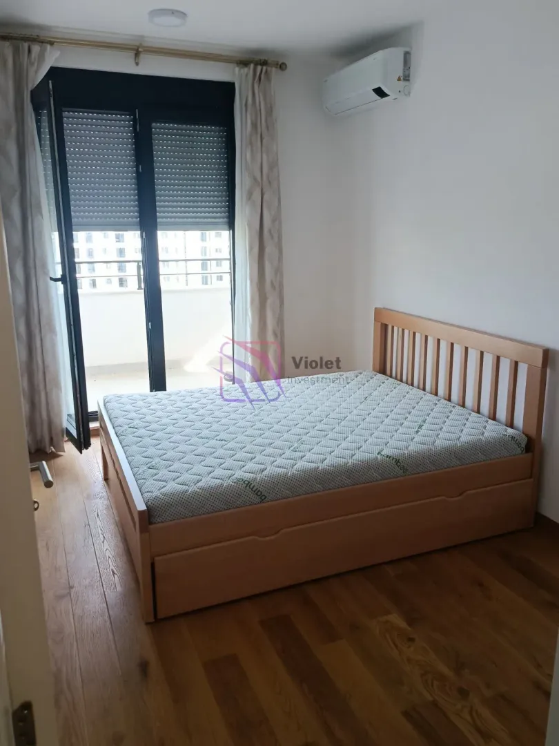 Spavaća soba sa bračnim krevetom i izlazom na terasu.