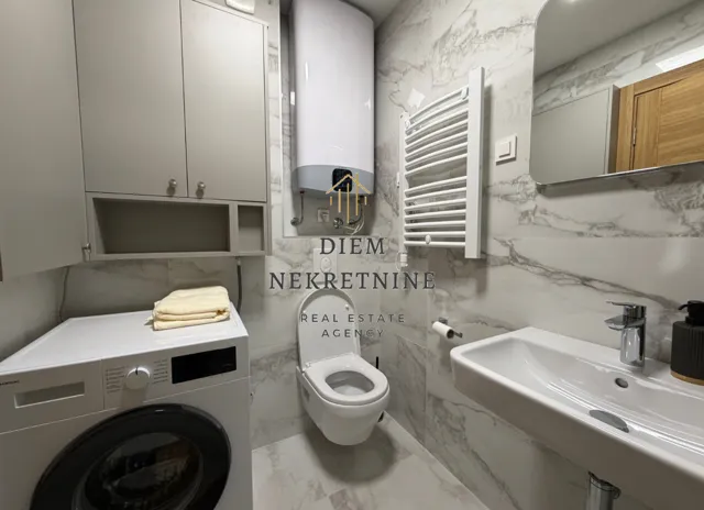 Modernly equipped bathroom with a washing machine and white sanitary ware.