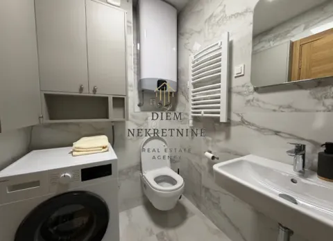 Modernly equipped bathroom with a washing machine and white sanitary ware. - image 16