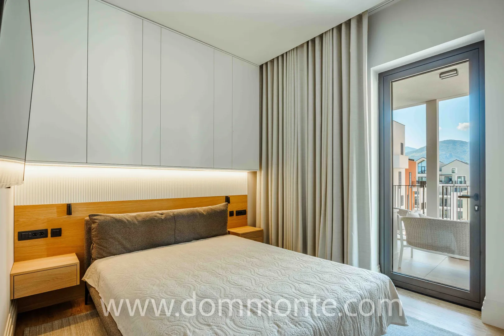 Modern bedroom with a double bed, built-in wardrobes, and access to the terrace.