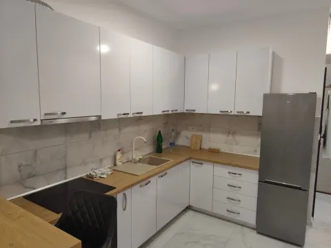 Moderna bela kuhinja sa drvenom radnom pločom i frižiderom. - image 5