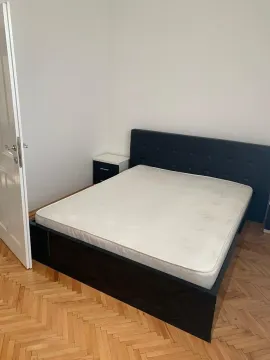 A bright bedroom featuring a double bed and wooden parquet flooring. - image 17