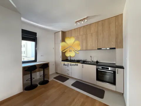 Modern kitchen with wooden cabinetry and a built-in bar with two chairs. - image 4