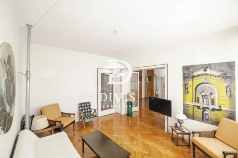 Dnevna soba sa drvenim parketom, nameštajem i televizorom na zidu. - image 12