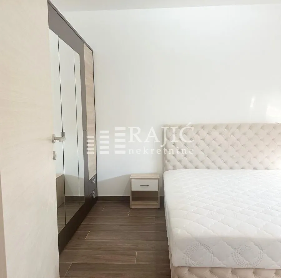 Furnished bedroom with a double bed and a fitted wardrobe.