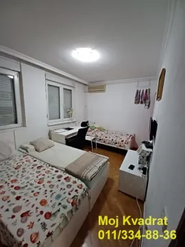 Spavaća soba sa dva kreveta, radnim stolom i prozorima. - image 9