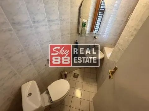 Small tiled bathroom equipped with a toilet, sink, and mirror. - image 18