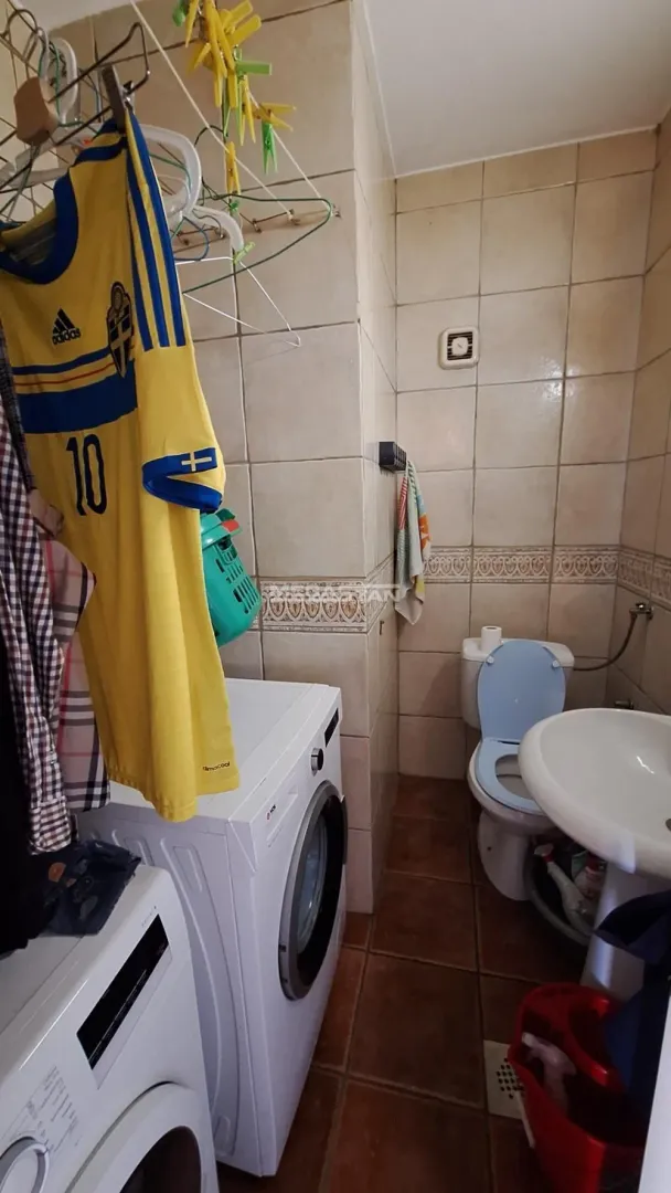 Kupatilo opremljeno toaletom, umivaonikom i veš mašinama.