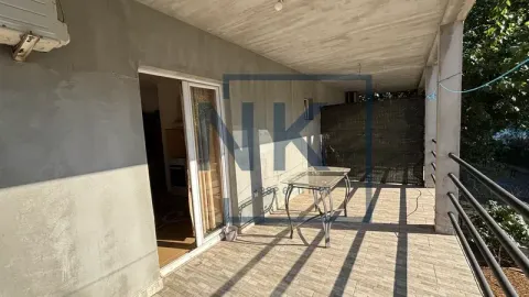 Covered terrace with a table and access to the interior of the building. - image 9