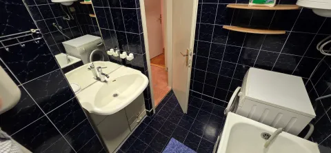 Manje kupatilo sa tamnim pločicama, umivaonikom i kadom. - image 9