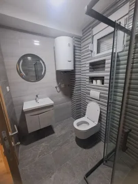 Modernly equipped bathroom with a shower cabin, washbasin, and toilet. - image 11
