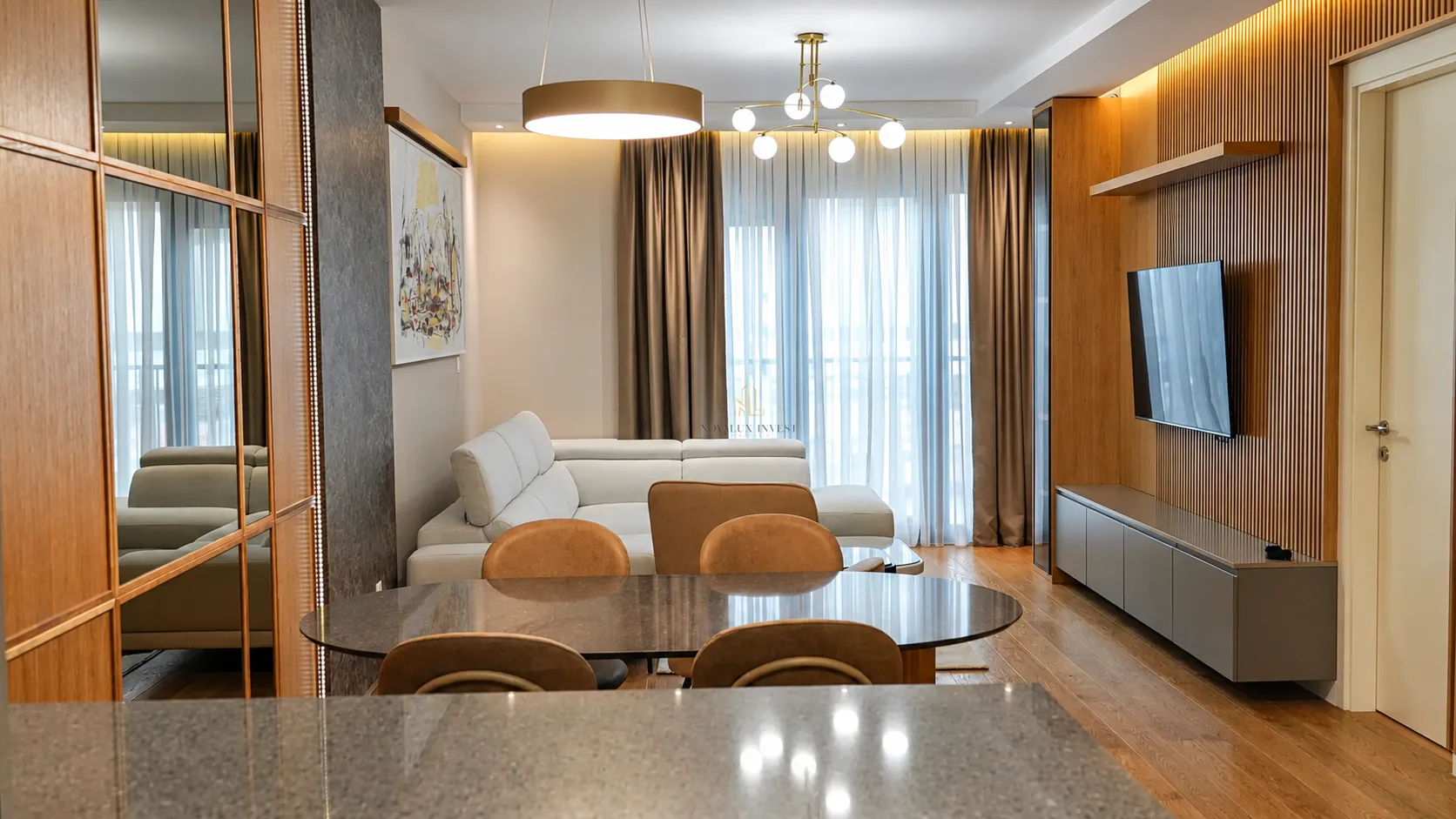 Modern living room with sofa, dining table and TV unit.
