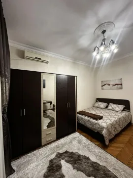 Furnished bedroom with a double bed, large wardrobe, and air conditioning unit. - image 3