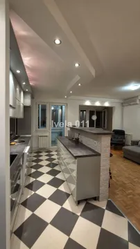 Moderna kuhinja sa šankom i crno-belim keramičkim pločicama na podu. - image 5