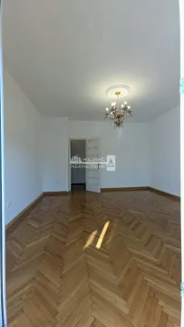 Empty room with hardwood parquet flooring and a chandelier on the ceiling. - image 20