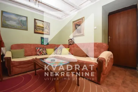 Dnevna soba sa ugaonom garniturom, klub stolićem i slikama na zidu. - image 2