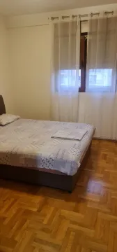 Svijetla spavaća soba sa bračnim krevetom i drvenim parketom. - image 4
