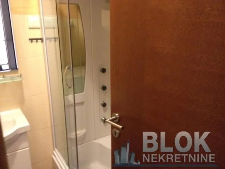 View of the bathroom with a shower cabin through the open door.