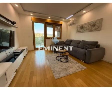 Dnevna soba sa garniturom, televizorom i izlazom na terasu. - image 6