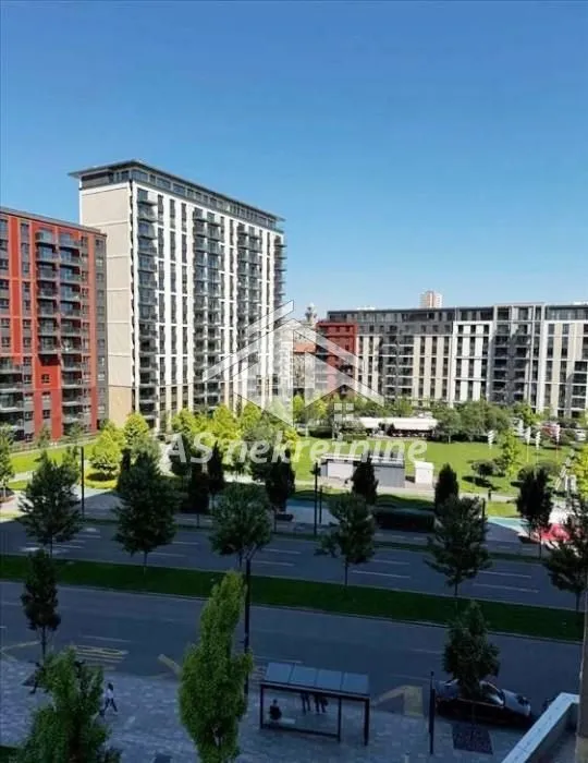 View from the window overlooking surrounding buildings and green area.