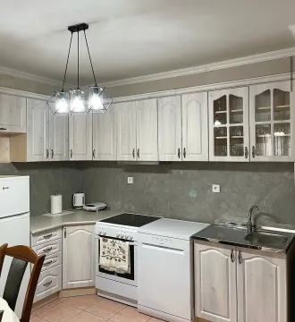Kitchen with light wooden cabinets, stove, refrigerator, and sink. - image 5