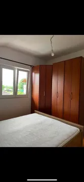 Bedroom with a double bed, wooden wardrobe, and a window. - image 9