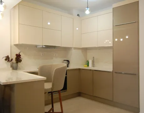 Modern kitchen with built-in cabinetry and a bar with a chair. - image 9