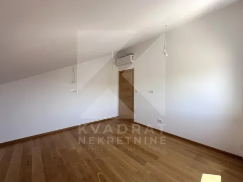 Empty attic room with wooden flooring and a door. - image 25