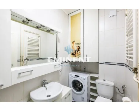 Manje kupatilo sa umivaonikom, WC šoljom, veš mašinom i velikim ogledalom. - image 5