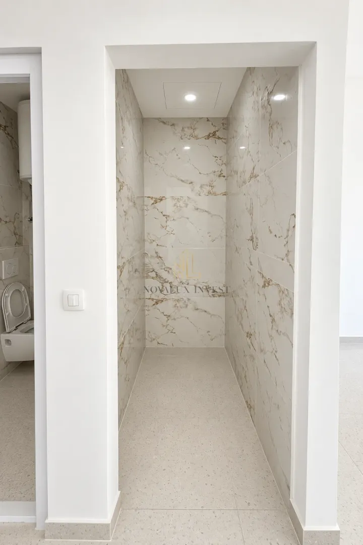 View of a bathroom tiled with marble-effect ceramic tiles.