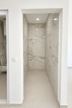 View of a bathroom tiled with marble-effect ceramic tiles. - image 7