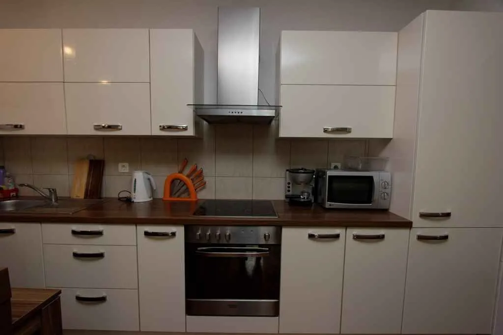 Bright kitchen with white cabinets and built-in appliances.