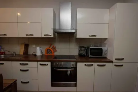 Bright kitchen with white cabinets and built-in appliances. - image 4