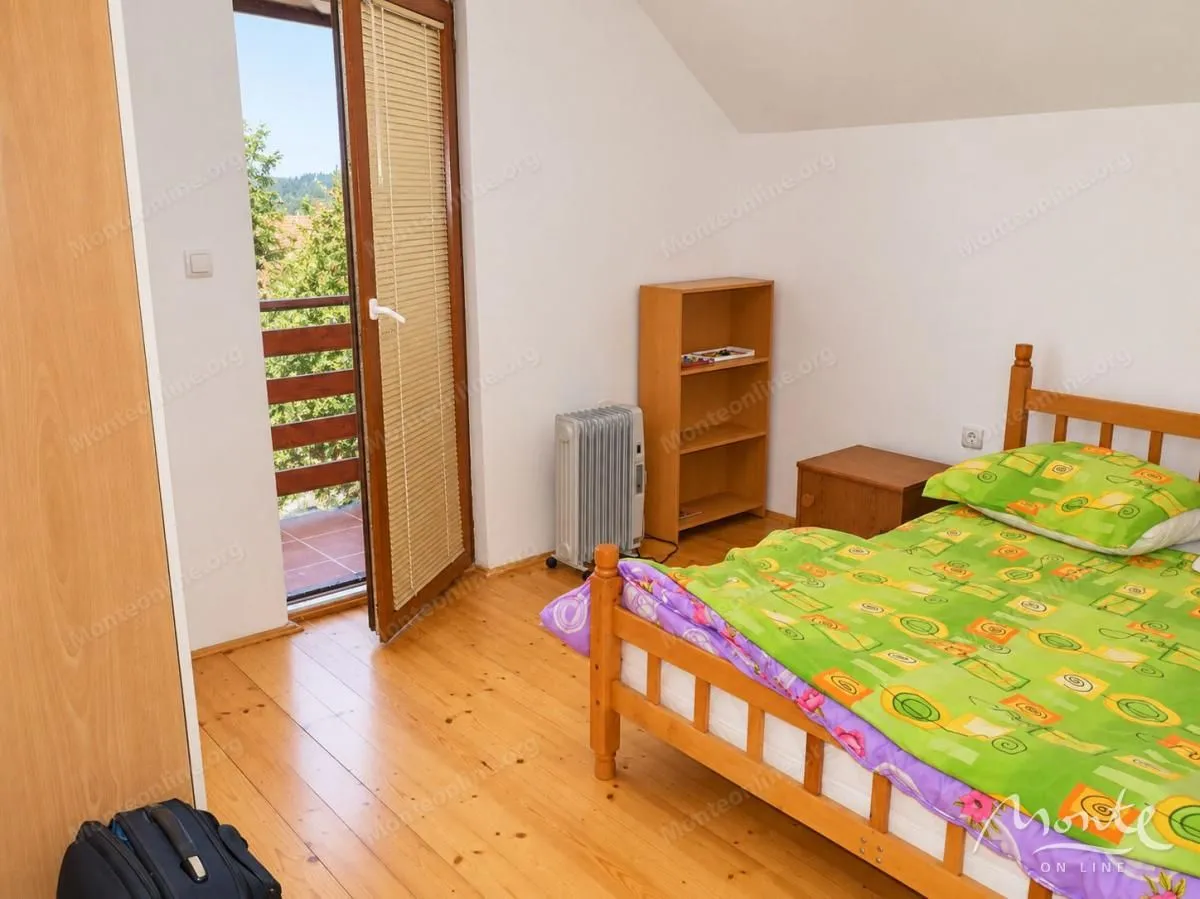 Furnished bedroom with a wooden bed and access to the terrace.