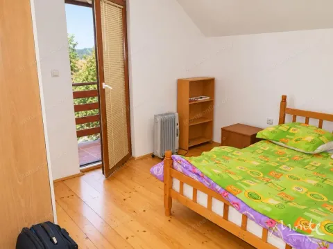 Furnished bedroom with a wooden bed and access to the terrace. - image 10