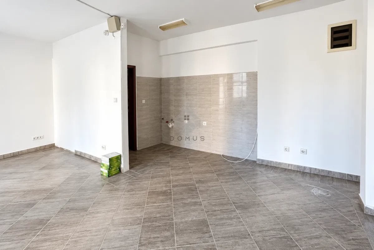 Empty room prepared for kitchen installation with ceramic tiles on the floor and walls.