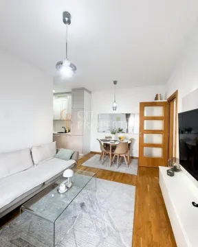 Dnevni boravak sa garniturom, trpezarijom i kuhinjom u pozadini. - image 7