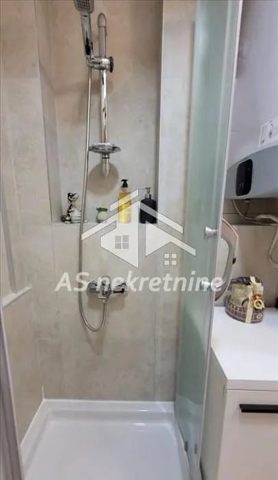 Tuš kabina sa ugradnom slavinom i pločicama u kupatilu.