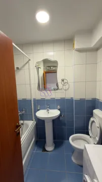 Kupatilo opremljeno umivaonikom, kadom i toaletom sa pločicama u plavoj i bijeloj boji. - image 3