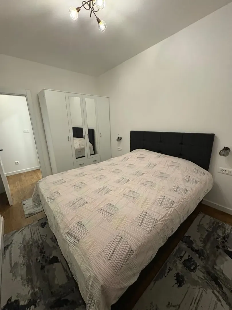 Bedroom with a double bed, wardrobe, and rugs.